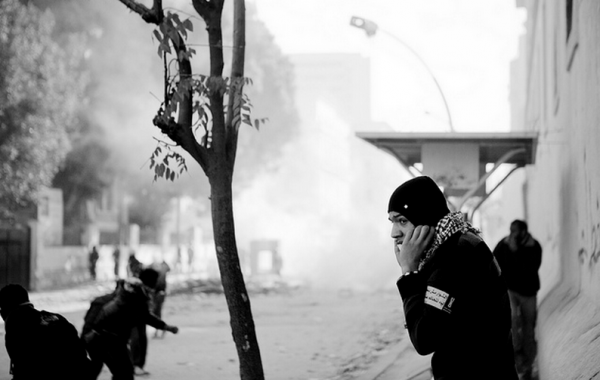 Manifestantes no Egito se protegem de bombas de gás lacrimogêneo jogadas pela polícia Foto: Hossam el-Hamalawy