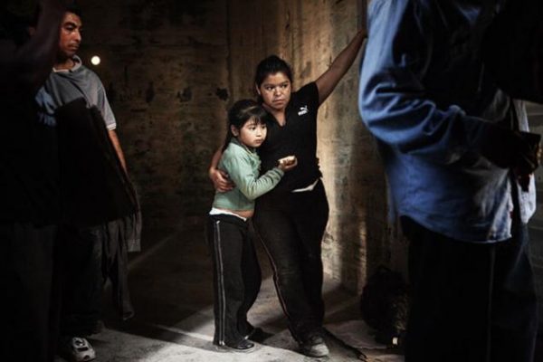 Mãe e filha imigrantes viajam dentro de um vagão de trem no estado mexicano de Chiapas