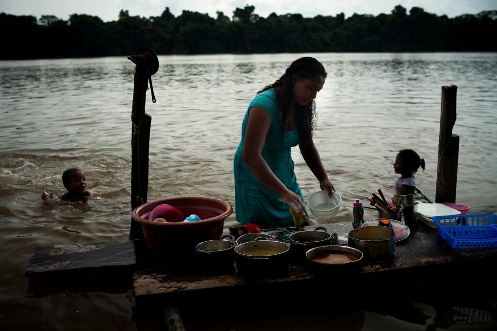 Ribeirinhos de Pimental vivem em integração com o Tapajós: hábito de lavar a louça no rio ajuda a atrair os peixes.
