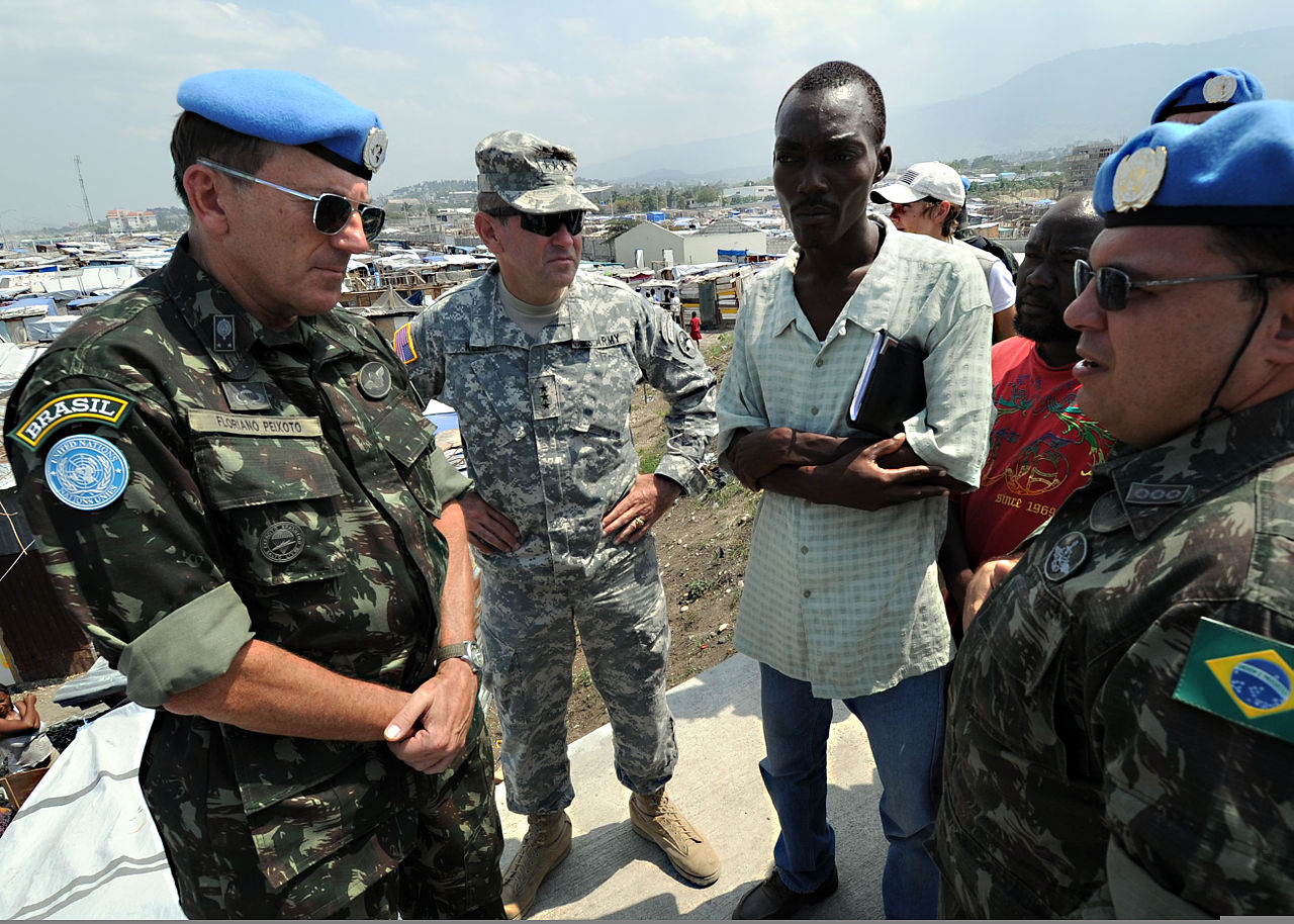 Oficial da Minustah, missão da ONU liderada pelo Brasil no Haiti, conversa com haitiano e oficial do exército norte-americano em Porto Príncipe