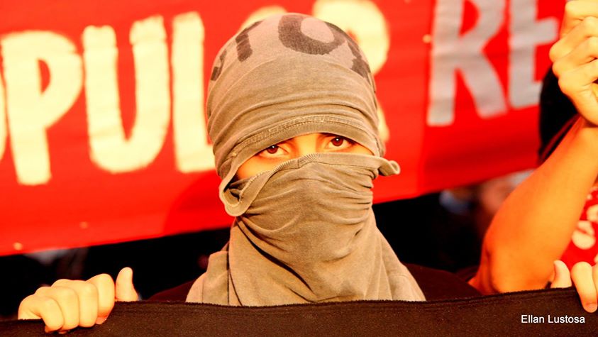Manifestante com rosto protegido durante protesto. Foto: Ellan Lustosa