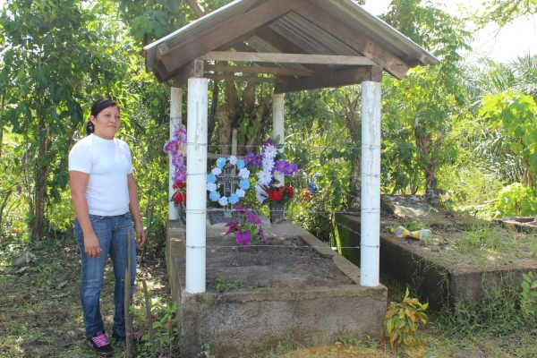Glenda Chávez, ao lado do túmulo do pai, Gregorio Cháves, cujo corpo foi encontrado em um latifúndio de Dinant em Paso Aguán.