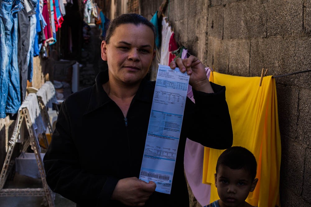 Marileide Maria da Silva, moradora do Jardim das Gaivotas, exibe a conta que paga pelo serviço não prestado: seu esgoto cai direto na represa Billings, sem tratamento. Foto: José Cícero da Silva