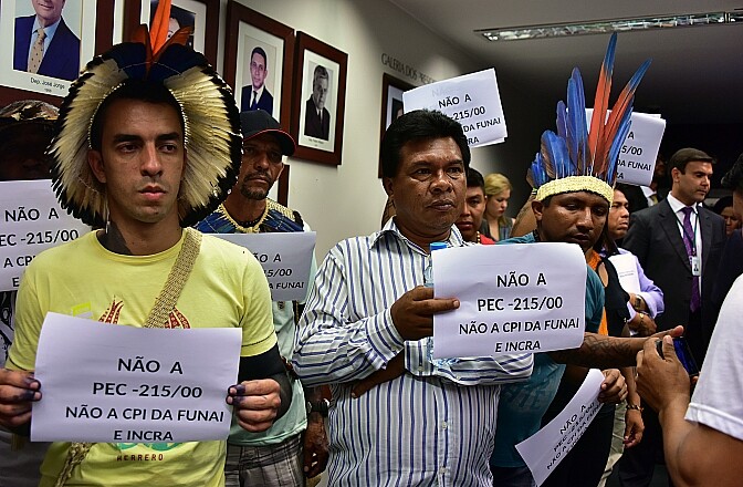 Manifestantes mostram cartazes contra a PEC 215 na CPI da Funai e do Incra, na terça-feira (24)