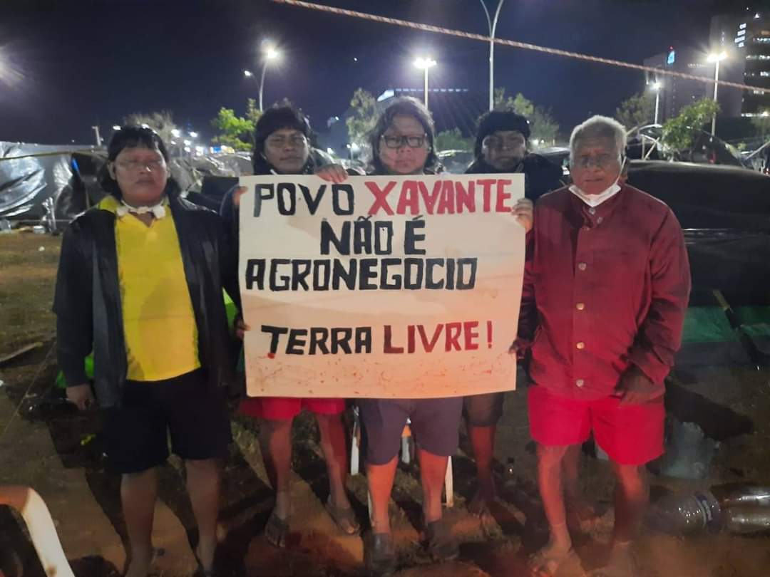 Indígenas Xavantes seguram cartaz escrito 