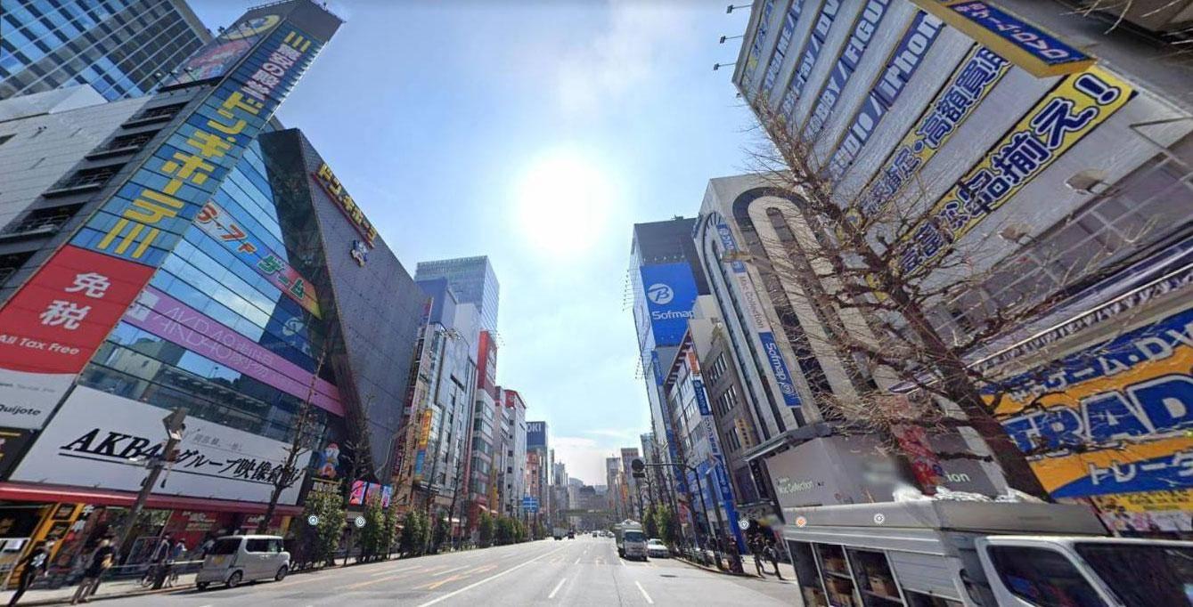 Avenida em Tóquio cercada de prédios e letreiros