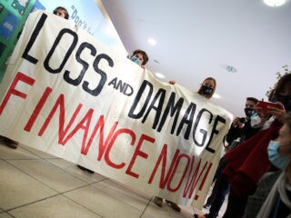 Na COP-26, manifestantes seguram faixa que pede "financiamento para perdas e danos agora"