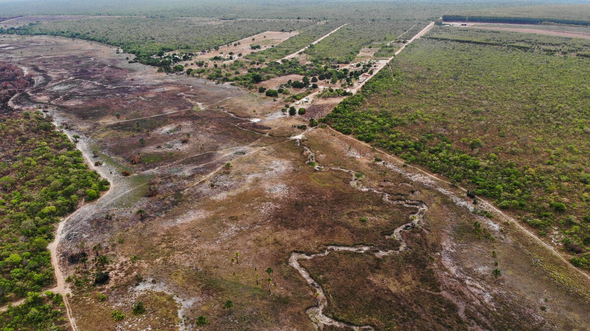 Imagem aérea mostra um rio totalmente seco, com pouca vegetação ao redor