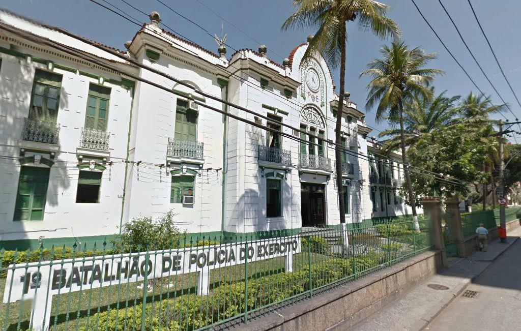 O edifício do 1° Batalhão de Polícia do Exército do Rio de Janeiro é um prédio com arquitetura antiga, pintado de branco com portas e janelasverde. Na frente do prédio há uma cerca com grades e uma placa escrito 1° Batalhão de Polícia do Exército