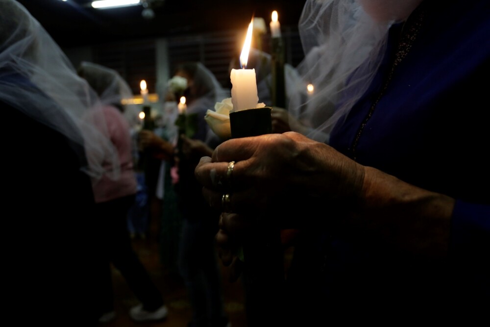 Moradores acendem velas em procissão 