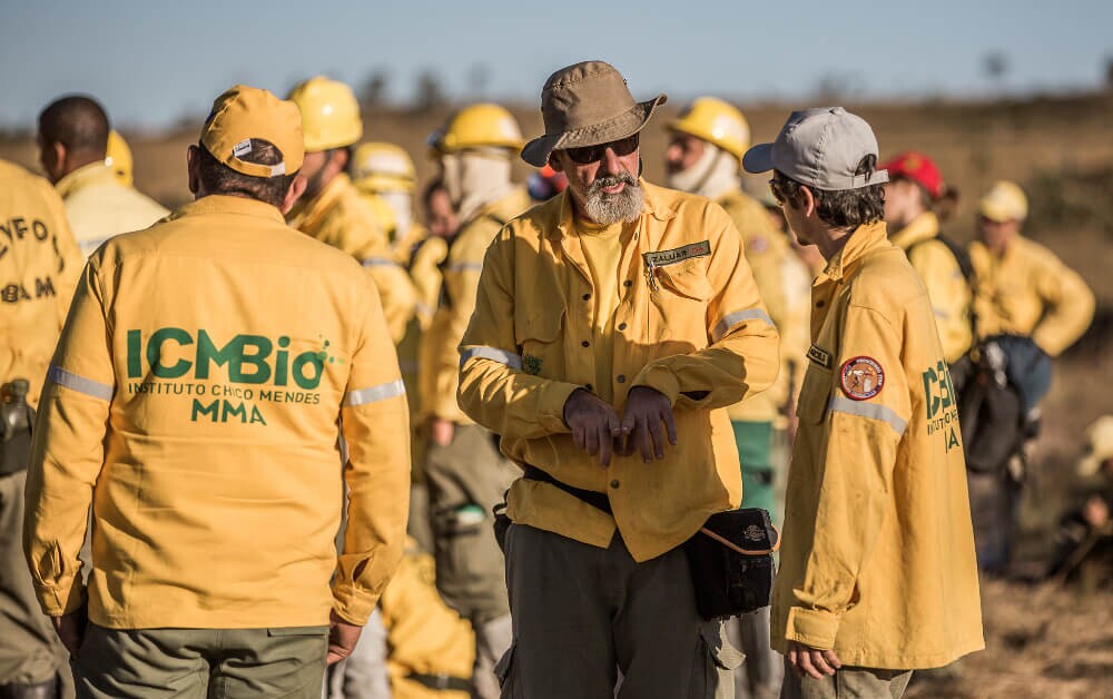 Funcionários do ICMBio vestem casaco amarelo com o nome do órgão em verde escrito nas costas