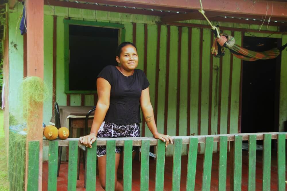 Moradora posa em varanda na frente de sua residência