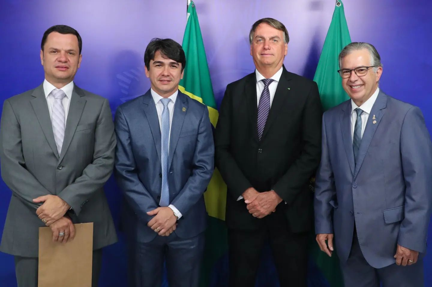 Anderson Torres (à esquerda), Wescley Tomaz (ao centro), Jair Bolsonaro (ao centro) e Joaquim Passarinho (à direita). Todos são brancos com cabelos castanhos e grisalhos, vestindo ternos cinza e preto, com gravatas azul.