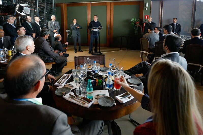 Presidente da República Jair Bolsonaro durante sua fala no Congresso Mercado Global de Carbono, rodeado por dezenas de convidados