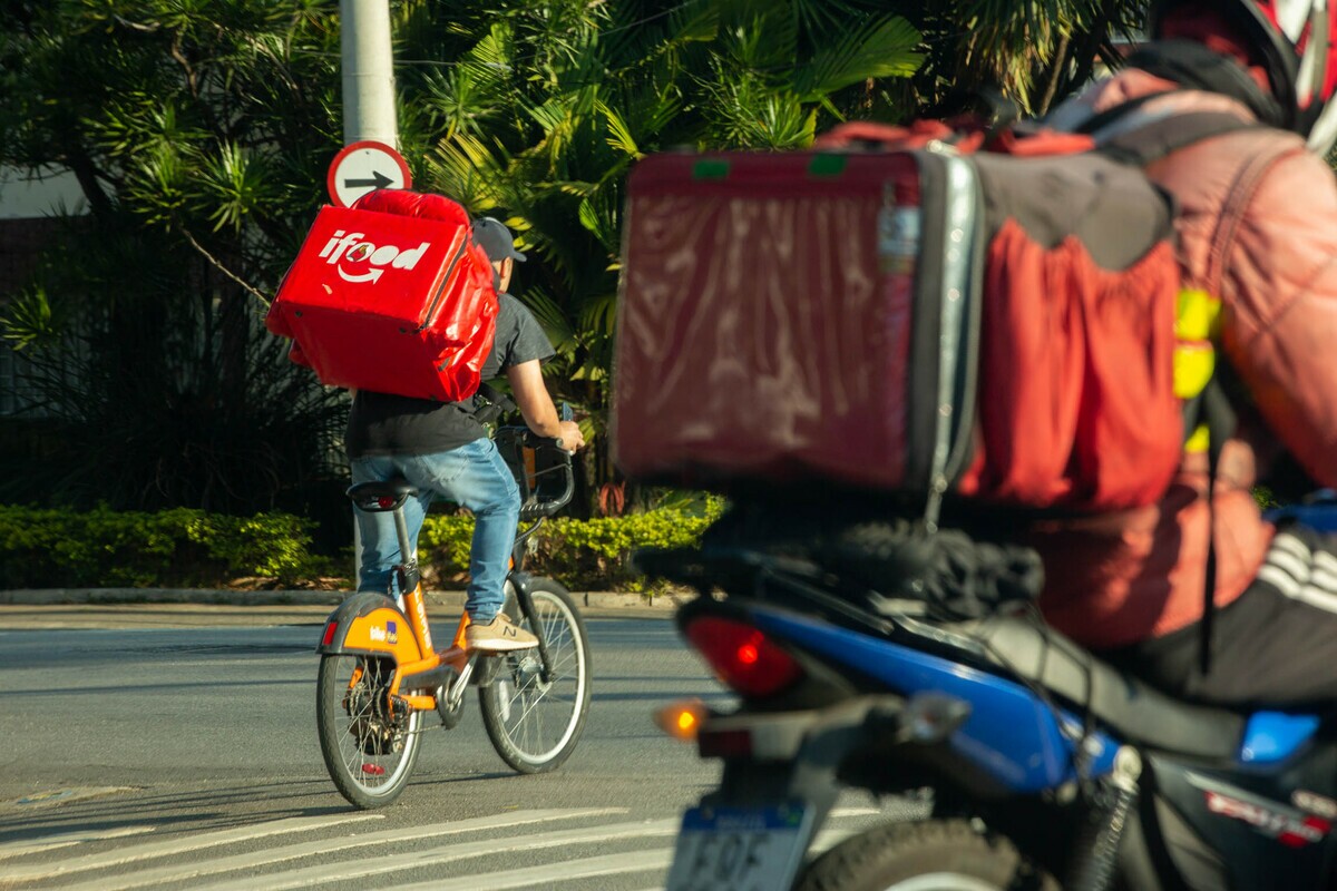 Entregadores de aplicativo com a mochila vermelha do iFood