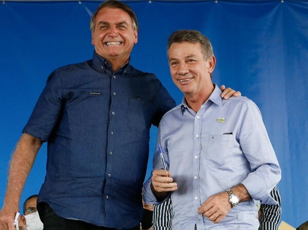 Antonio Denarium (PP) é um homem branco com cabelos e olhos escuros, ele veste camisa azul clara e está ao lado do presidente Jair Bolsonaro.