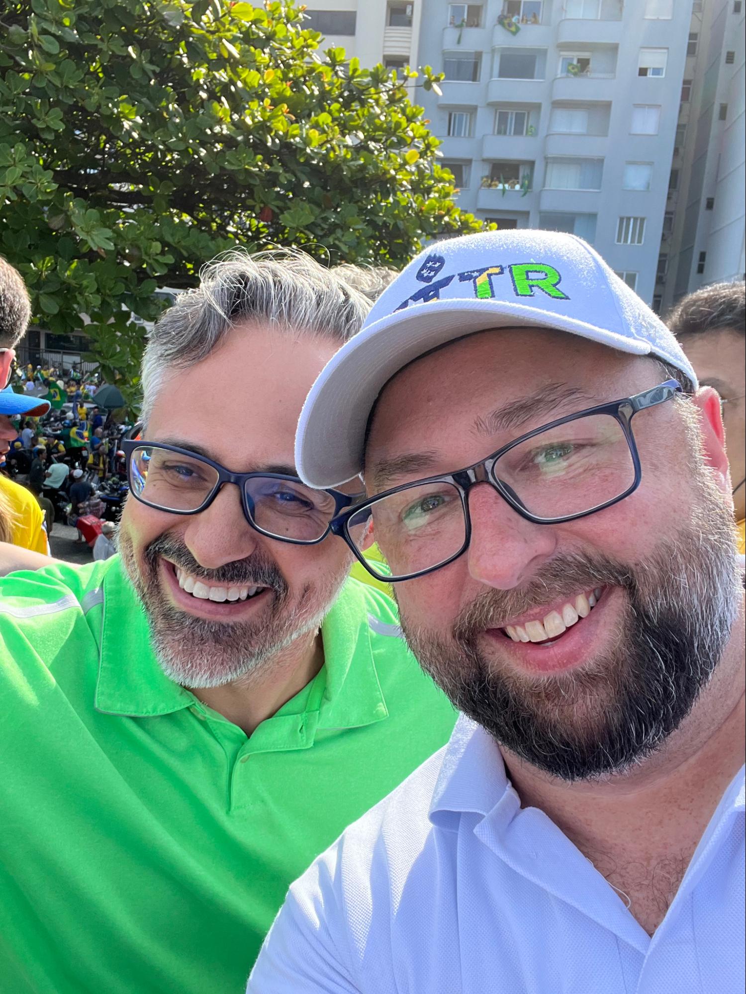 Jason Miller (à dir), CEO da Gettr, é um homem branco com barba grisalha, ele usa boné da Gettr, óculos e camisa branca. Jason Miller esteve no Brasil para o 7 de setembro.