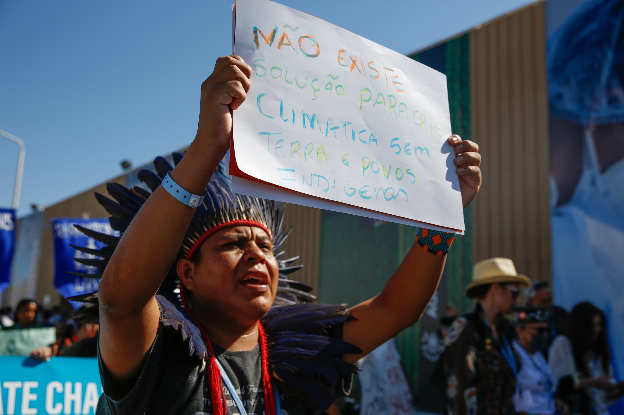 Na COP27, um homem indígena protesta contra as mudanças climáticas e perda de terras pelos povos indígenas.