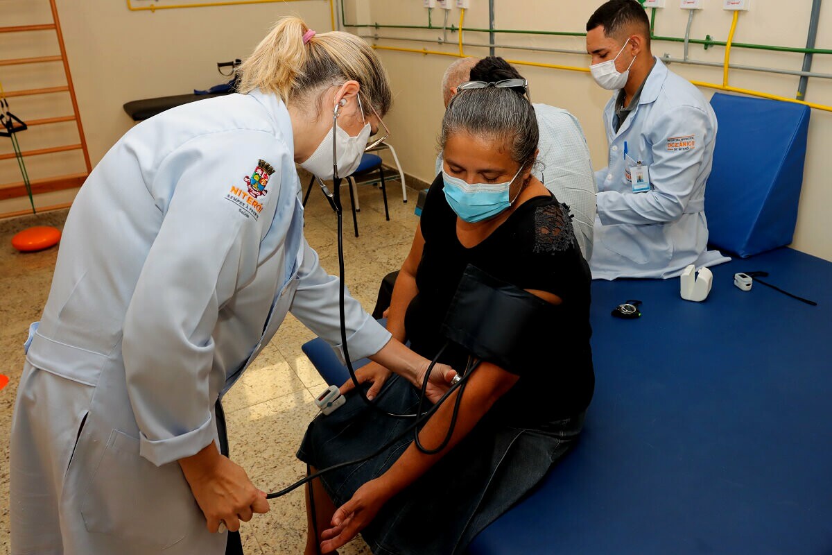 Enfermeira mede a pressão de paciente em hospital