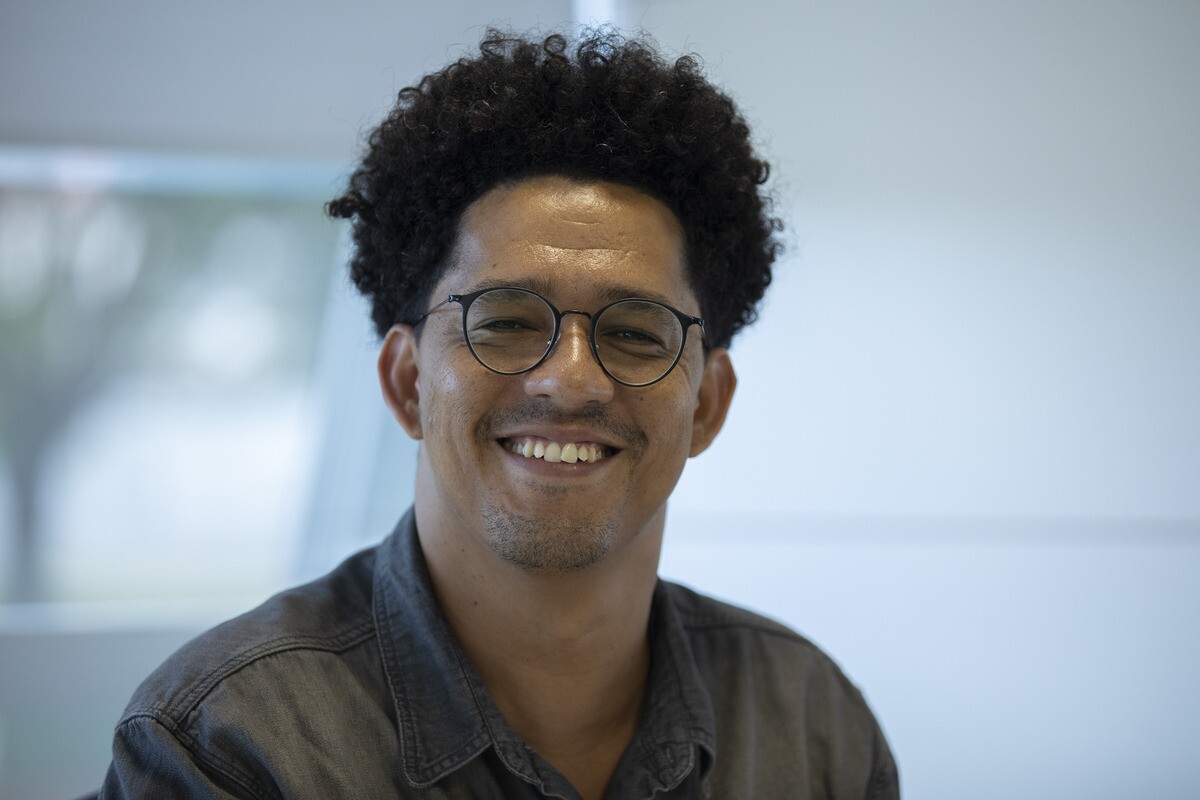 Guilherme Simões, coordenador da Secretaria Nacional de Políticas para Territórios Periféricos. Simões é um homem negro de 38 anos, ele tem cabelo afro escuro e veste camisa jeans social