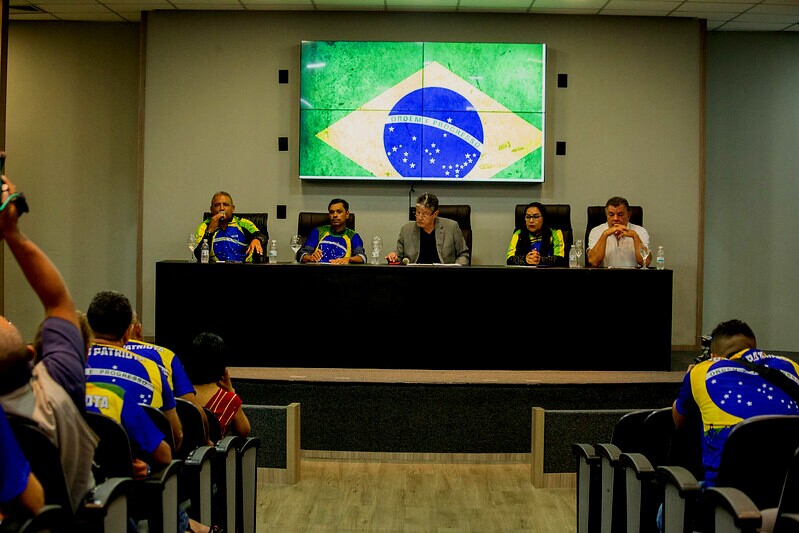 Lideranças do Movimento Garimpo Legal (MGL) durante comissão da Assembleia Legislativa de Roraima, na imagem a maioria das pessoas aparecem usando camisetas estampadas com a bandeira do Brasil e ao fundo também é projetado a bandeira brasileira.