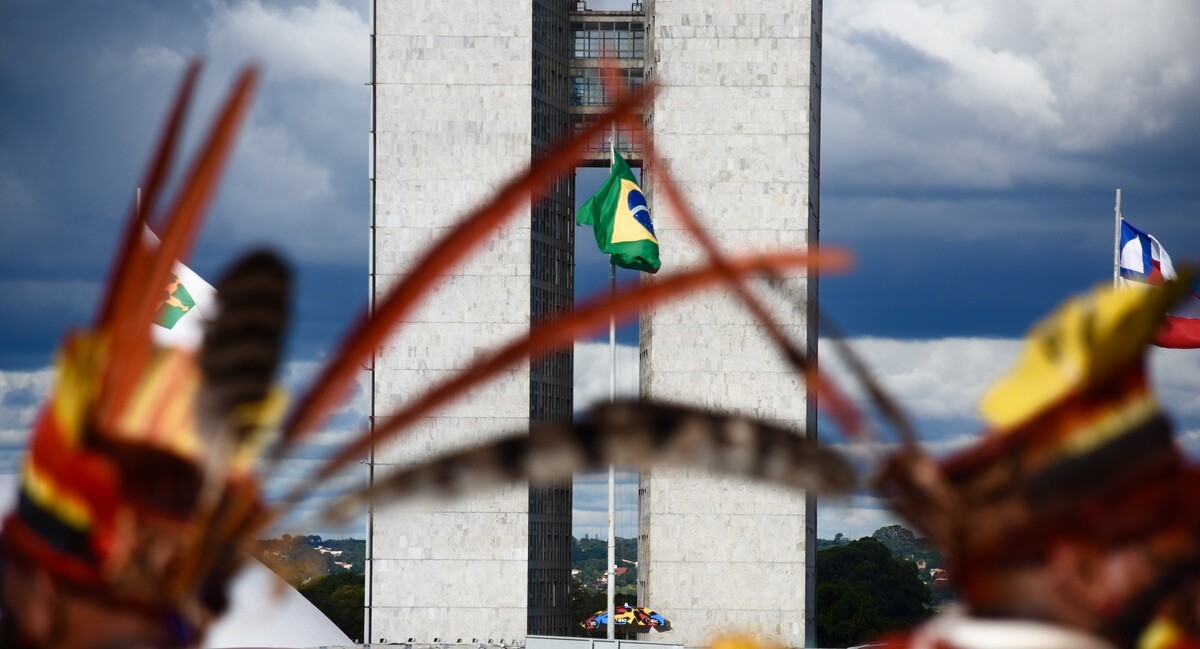 Indígenas de costas na Praça dos Três Poderes em Brasília durante o ATL