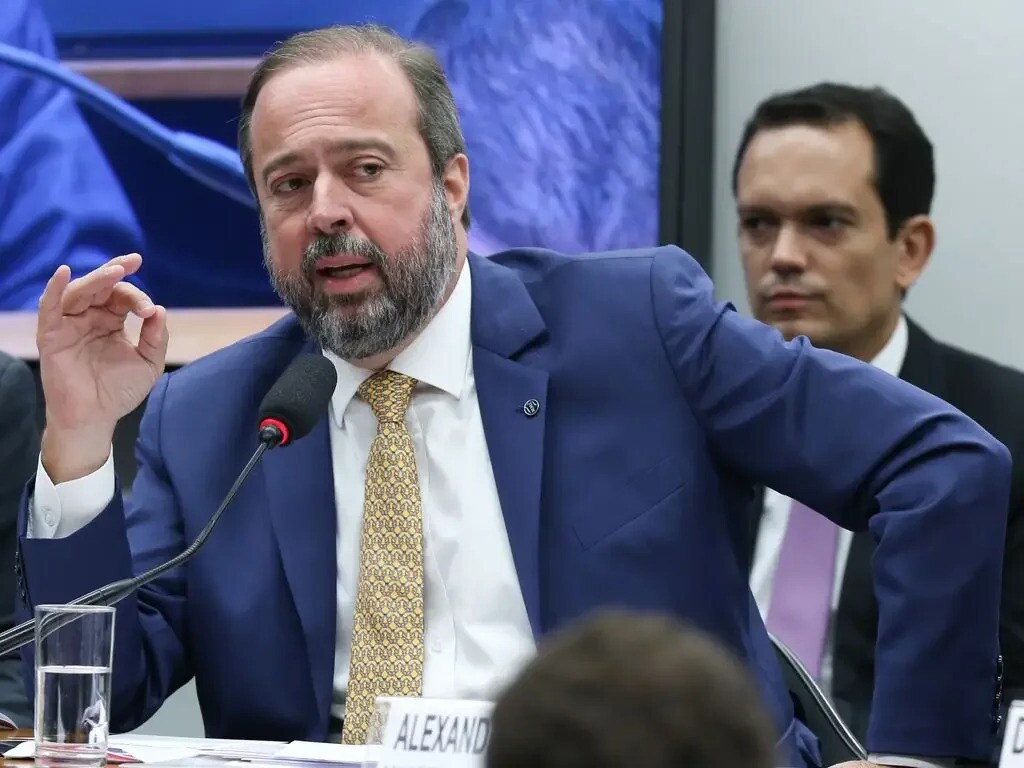 Ministro de Minas e Energia Alexandre Silveira (PSD) é um homem branco, calvo, com barba grisalha. Na imagem, ele veste um terno azul, e gravata amarela estampada, ele fala ao microfone.