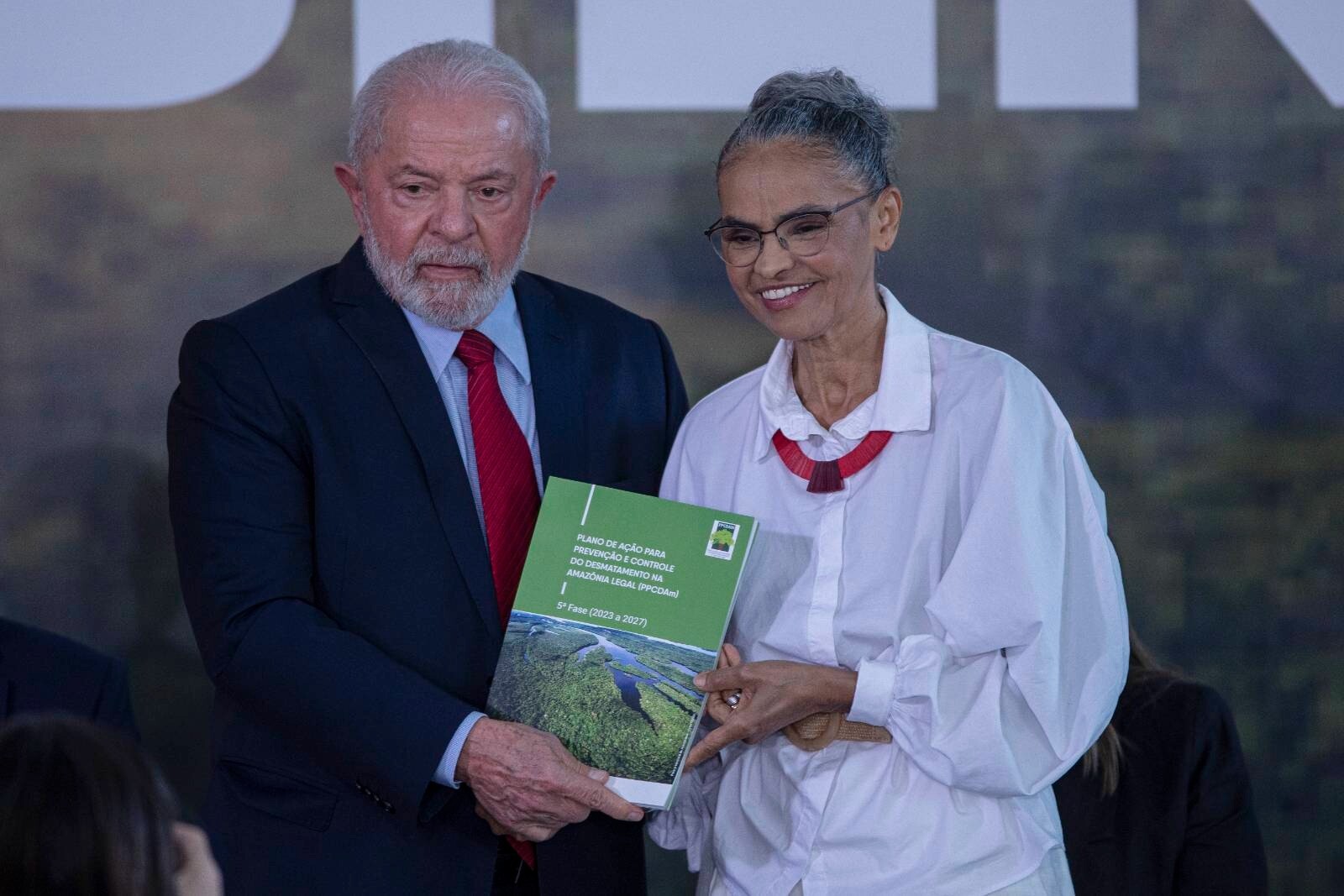 À esquerda o Presidente Lula e ao seu lado a Ministra do Meio ambiente Marina Silva, eles sorriem para a foto no evento de lançamento do Plano de Ação para a Prevenção e Controle do Desmatamento na Amazônia Legal