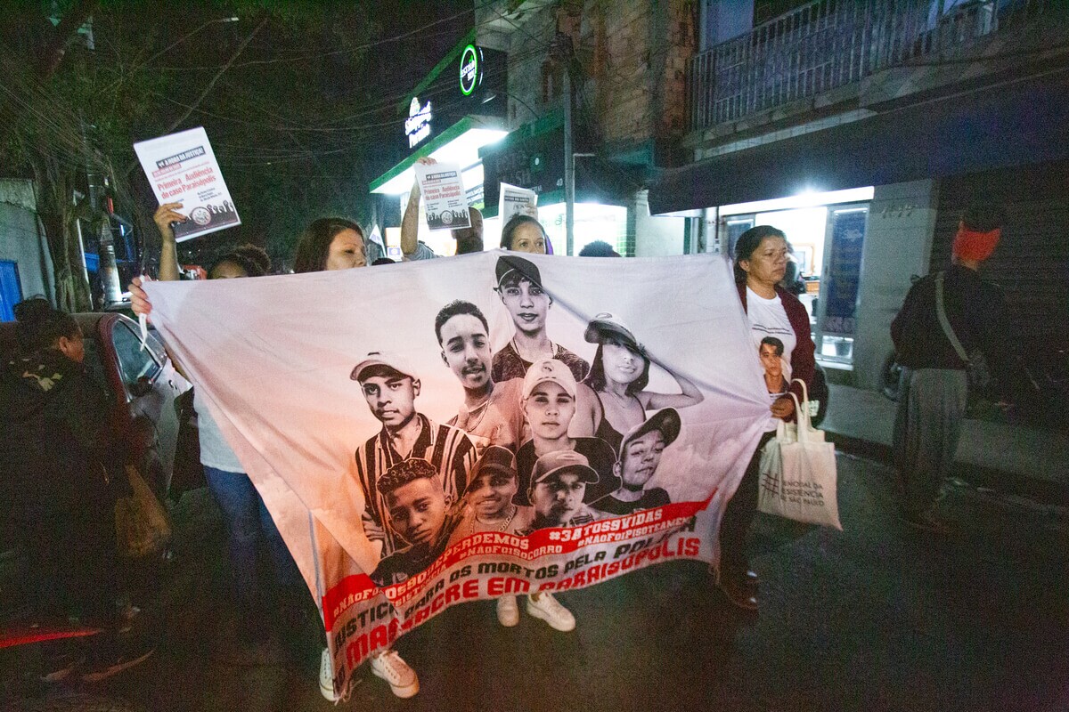 Familiares das vítimas do Massacre de Paraisópolis andam pelas ruas do bairro com faixa com as fotos das vítimas