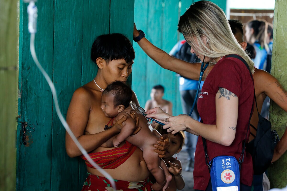 Médica do SUS examina bebê Yanomami.