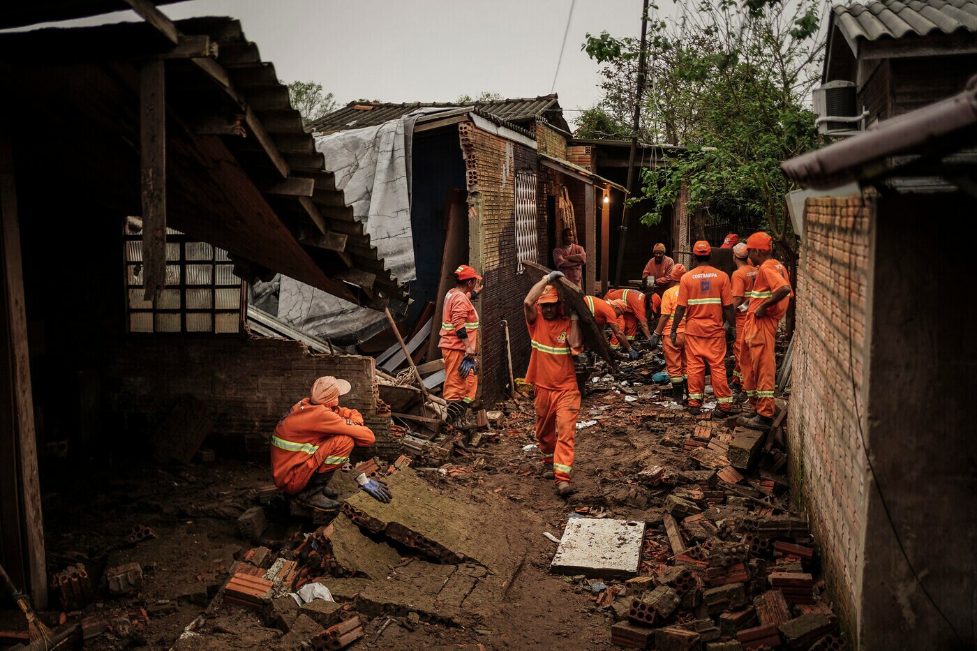 Agentes da defesa civil caminham em meio à casas destruídas pelas enchentes no Rio Grande do Sul