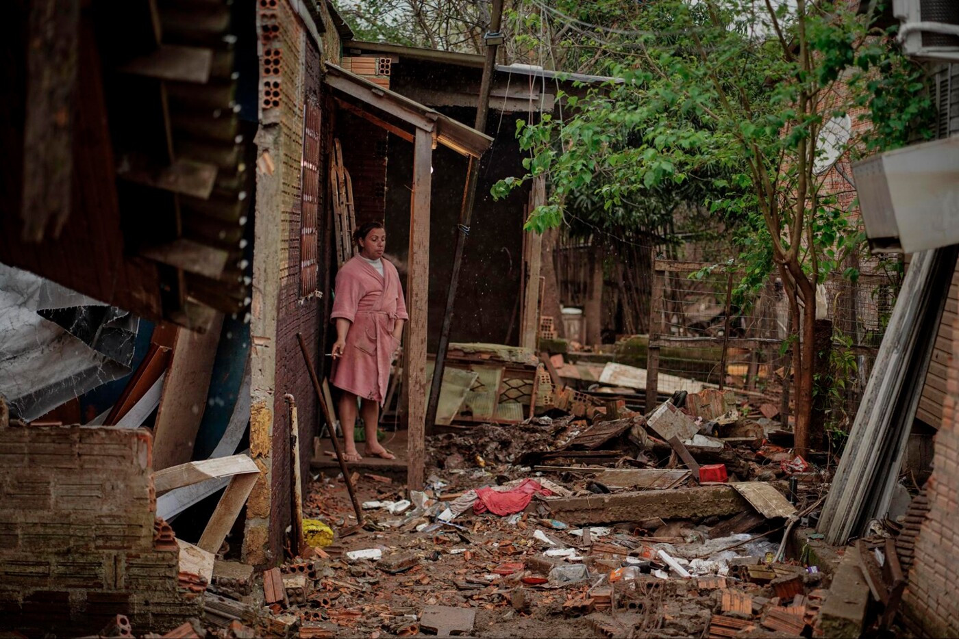 Mulher mostra escombros de casa após enchentes no Rio Grande do Sul