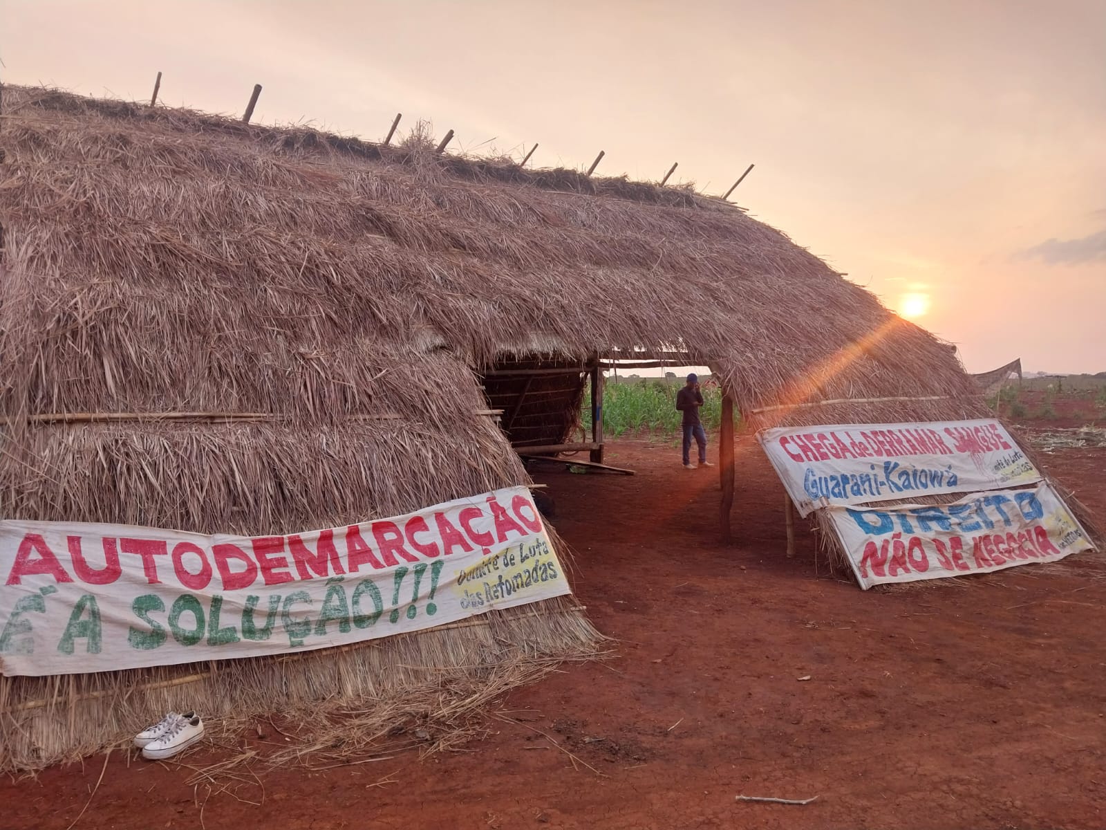 Imagem mostra cartazes fixados em tenda Guarani Kaiowá contra violência e à favor da demarcação de terra indígena