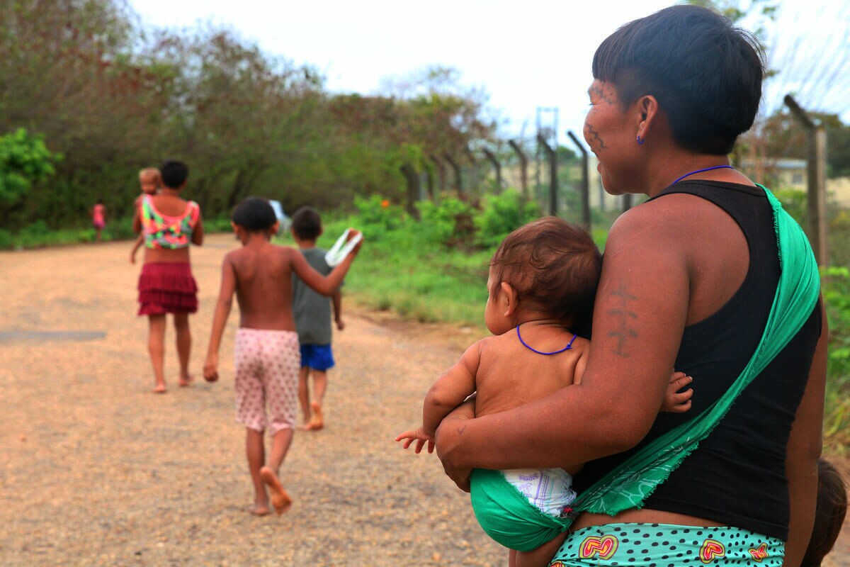 Mulher indígena com bebê em frente ao Hospital de Campanha Yanomami montado na Casa de Saúde Indígena - Casai em Roraima