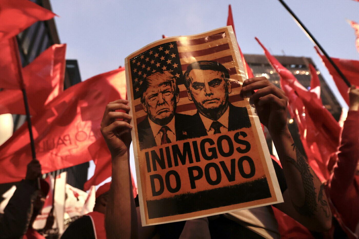 Cartaz com as fotos de Donald Trump e Jair Bolsonaro com os dizeres "inimigos do povo", em manisfestação contra os Estados Unidos