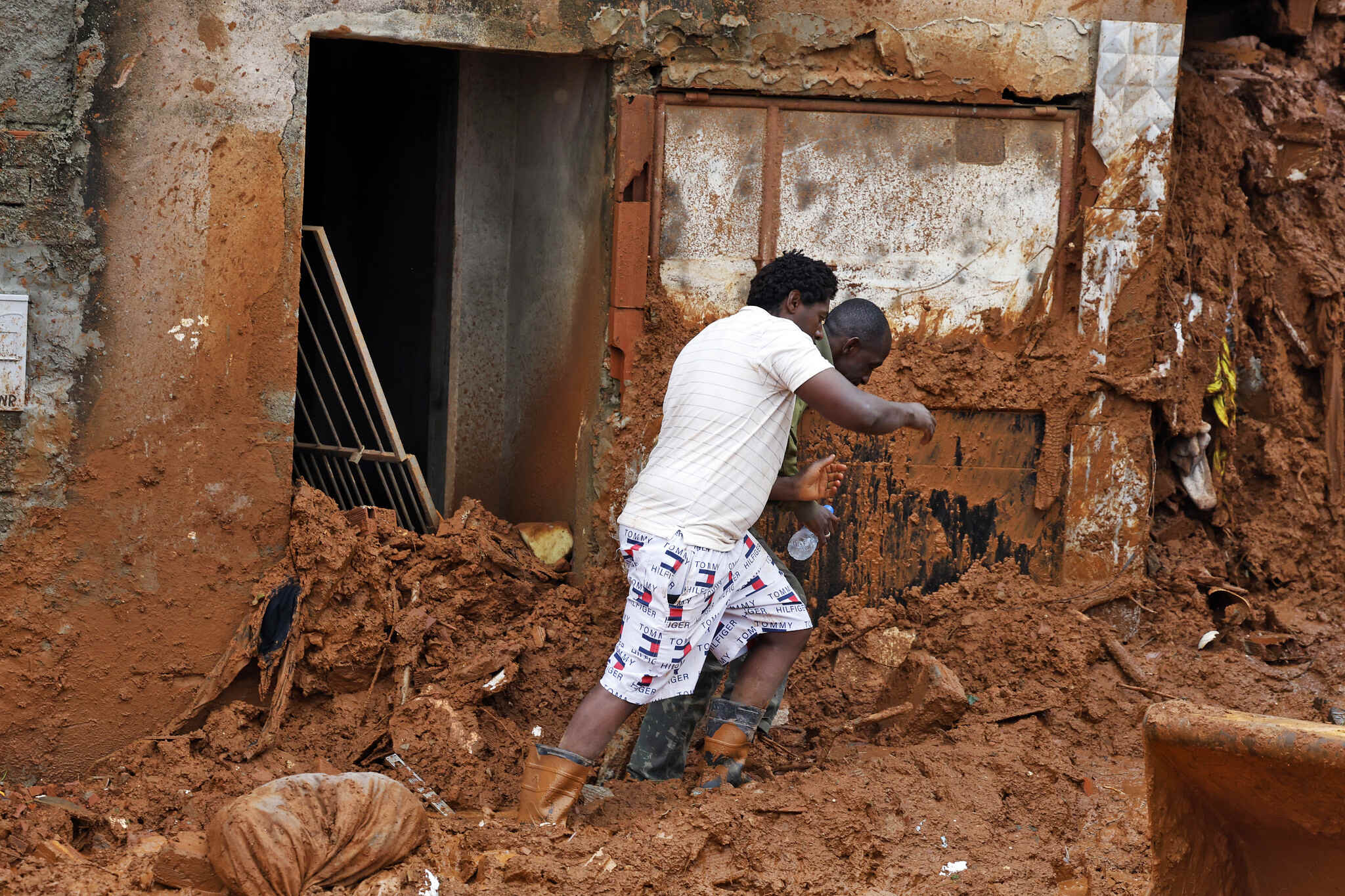 Juiz de Fora (MG), 24/02/2026 - Familiares acompanham busca e resgate de pessoas em escombros de casas soterradas por lama após fortes chuvas